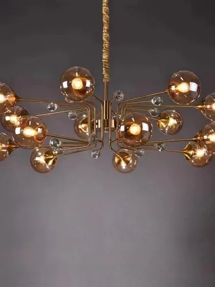 A modern brass chandelier with smoked glass globes. The combination of the warm metal finish and the tinted glass creates a sophisticated, mid-century modern look perfect for a stylish home.