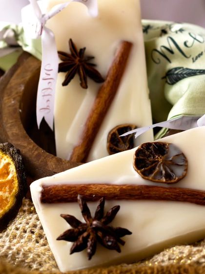 These wax sachets, infused with cinnamon, star anise, and dried orange, are styled with rustic elements like jute fabric and a wooden bowl. The warm, spicy visuals perfectly match the scent.