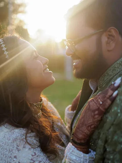 This is the kind of candid moment we live for. A close-up portrait of a couple sharing a genuine laugh, backlit by the golden hour sun, showcasing the pure, unposed joy that defines their relationship.