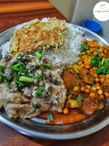 A delicious combination plate with a pork side dish, a mash of betel leaf and fox nut (paan ga thangjing eromba), spicy chickpeas (kelichana), and an omelette.