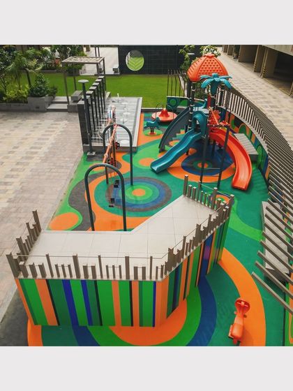 This view shows the variety of play equipment integrated into the landscape, including slides, spinners, and climbing structures, all within a cohesive design.