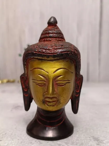 Yeh Buddha head ka multi-color version hai, jismein antique red aur gold finish hai.
