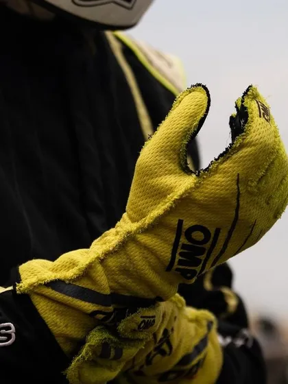 A close-up of a driver's worn racing glove, a symbol of the hard work and dedication required.