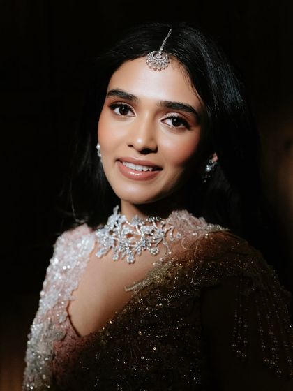 A dramatic close-up under soft lighting. This shot highlights the luminous quality of the skin and the soft shimmer on the eyes.