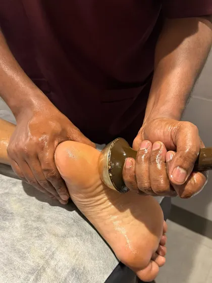 This is a Kansa wand foot massage, an ancient technique used to draw out heat and toxins from the body. It's incredibly relaxing for tired feet and helps balance the body's energies.