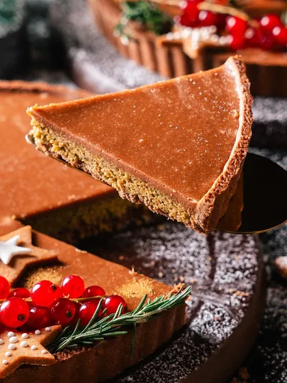 A slice of our Christmas Tart being lifted, showing the distinct layers of crunchy pistachio kunafa and smooth chocolate ganache. It's a preview of a truly unique holiday dessert.