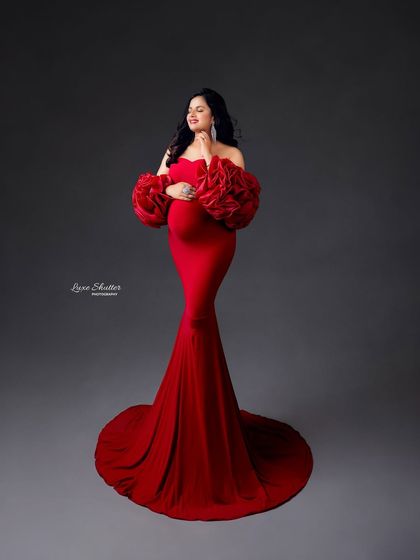 A full-length portrait showcasing the stunning silhouette of the red gown with its dramatic sleeves. A truly unforgettable look.