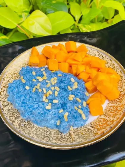 Presenting Thai Mango Sticky Rice. Our take on the classic dessert features vibrant blue rice colored naturally with butterfly pea flowers.