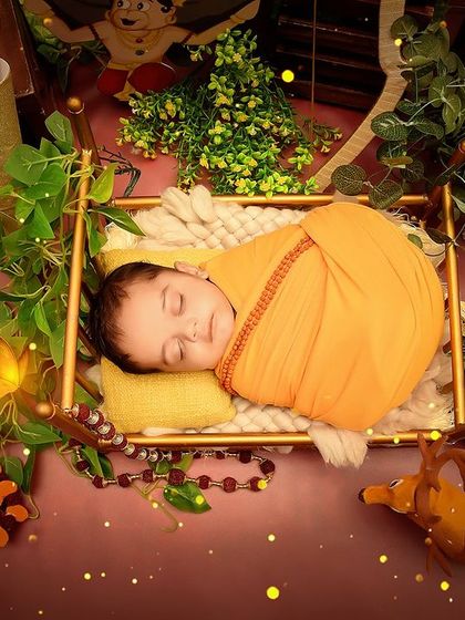 An overhead shot of the baby in the "Jai Shree Ram" setup, showing the rich details of the surrounding props and decor.