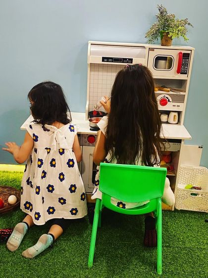 Deep in concentration, these two chefs work together to prepare a meal. Pretend play is great for cooperative fun.