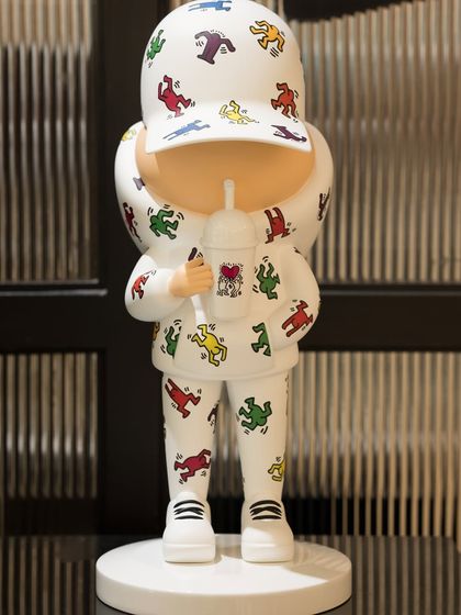 A full view of the 'Kid Cup (Keith Haring)' sculpture. This faceless figure by French-Brazilian duo Leo and Steph represents the joyful, optimistic inner child in all of us.