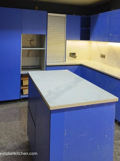 The L-shaped layout with the island provides an expansive and social workspace. Even during installation, the potential of this colorful and modern kitchen is clear.