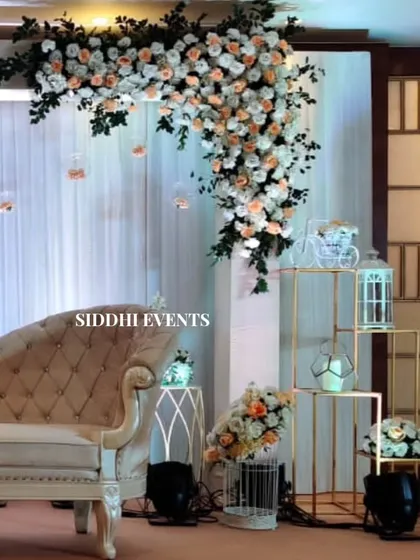 This side view of the reception stage highlights the cascading floral arrangement and the soft, romantic lighting from the hanging glass baubles.