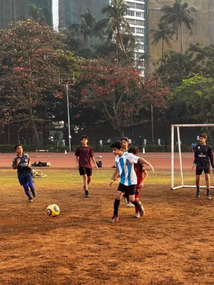 A player dribbles the ball during a practice match, showcasing the skills learned during our professional football coaching. We focus on building a strong foundation of discipline and passion for the sport.
