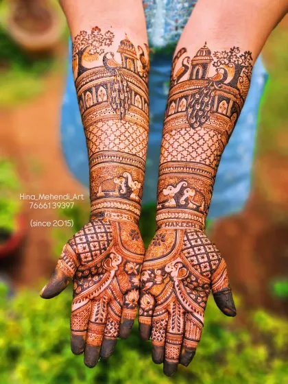 A traditional Rajasthani-style bridal mehendi featuring majestic elephants and palace architecture (jharokhas) on the forearms, with graceful peacocks on the palms.