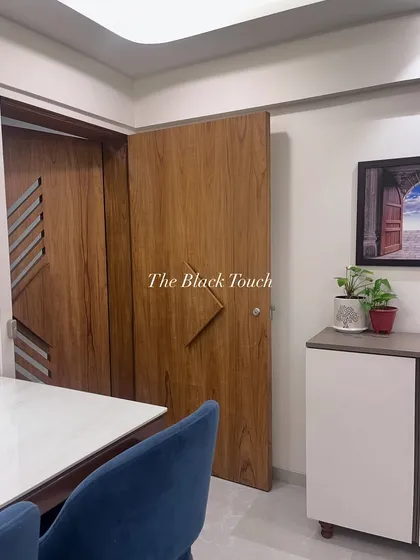 A view of the main door and dining area in our Ghatkopar project. The custom-designed safety door and main door feature a cohesive wooden finish that adds a touch of modern elegance right from the entrance.