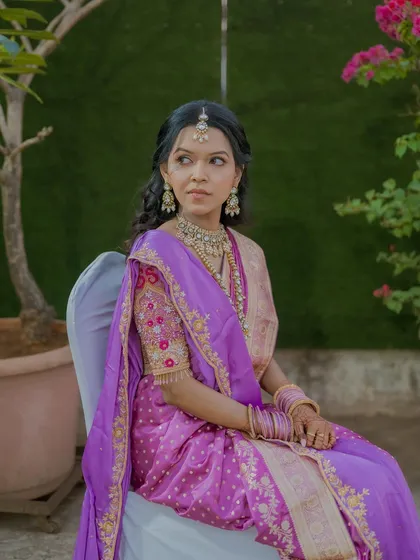 Seated portrait showcasing her complete engagement look, including the beautifully draped saree and the elegant half-up hairstyle.