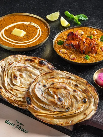 A meal for two from Dana Choga, featuring Dal Makhani, a chicken dish, and lachha parathas.