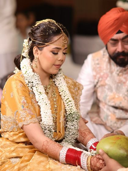 The bride participating in wedding rituals, her traditional hairstyle holding strong.
