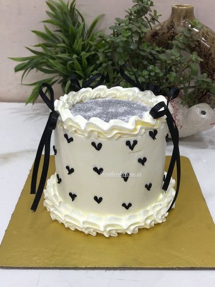 A chic glitter cake with black hearts and delicate black ribbon bows. This design is simple, modern, and perfect for a stylish birthday or bachelorette party.