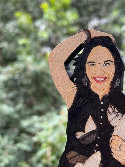 A close-up shot of the hand-painted details on a wooden miniature. I try to capture the likeness and personality of each person in my illustrations.
