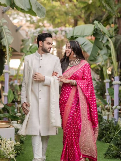 The couple takes a stroll through a garden path after their first look, sharing a loving glance, ready for their ceremony.