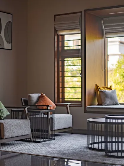 We created this cozy reading nook with a built-in window seat, perfect for enjoying a quiet moment. The combination of textured upholstery, dark metal accents, and warm wood creates an intimate and stylish corner.