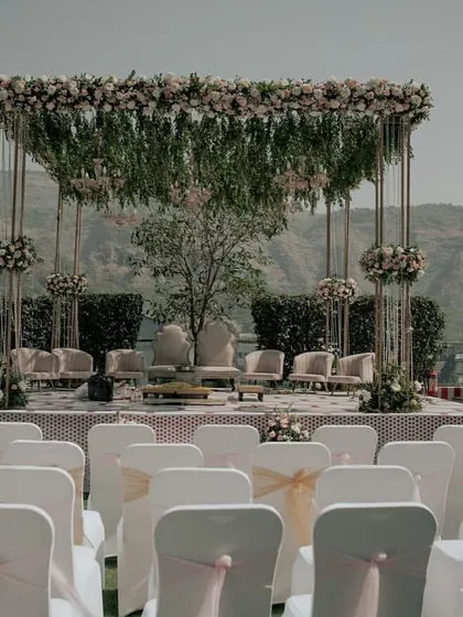A minimalist Vidhi Mandap set against a stunning mountain backdrop. The design uses clean lines and hanging florals to enhance, not obstruct, the natural beauty of the venue.
