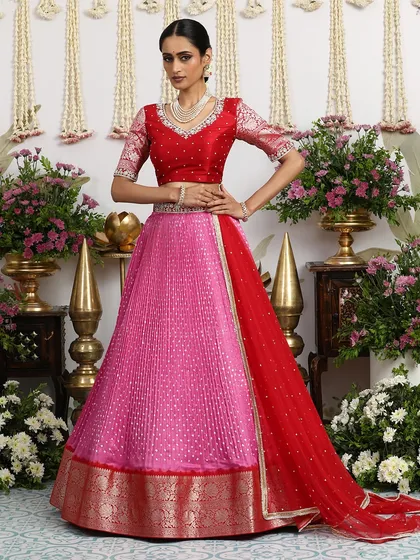 The full, standing view of the pink and red lehenga, showcasing its beautiful silhouette.