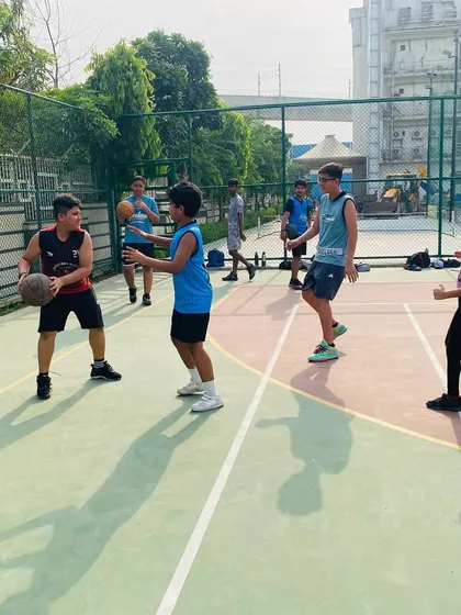 A young player learns to handle the ball while being defended.