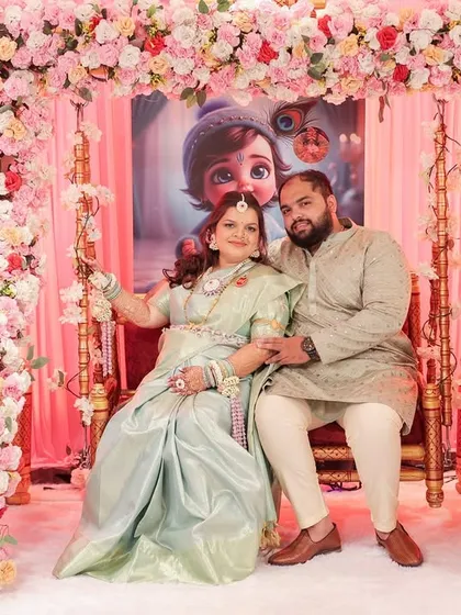 The couple seated on the traditional baby shower swing, with the mom-to-be adorned in her complete floral jewellery set.