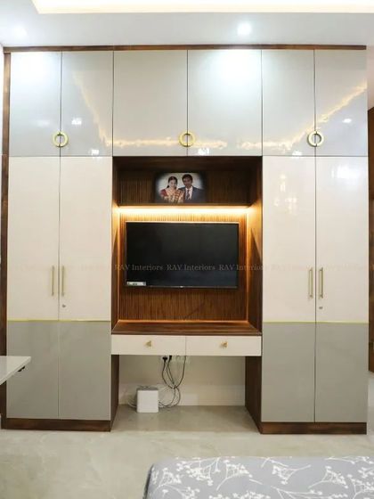 A bedroom wardrobe unit that cleverly incorporates a TV and a study desk, making it a perfect solution for compact rooms.