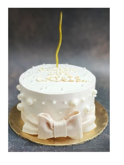 A minimalist bow cake inspired by a Pinterest design. This small chocolate cake is perfect for an intimate celebration, featuring a simple and elegant fondant bow.