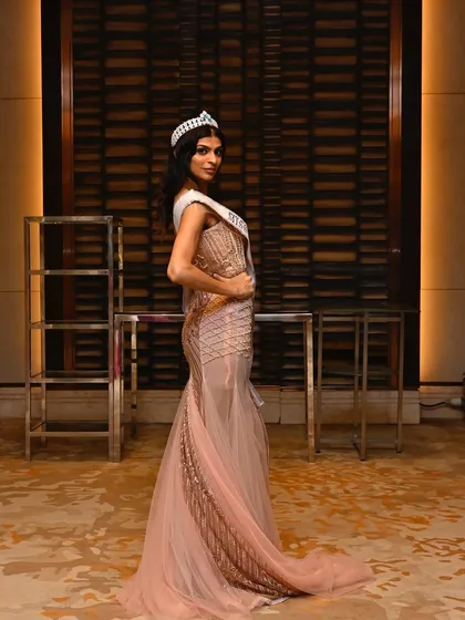 A side profile showcasing the sleek hairstyle and the contouring that defines her features for the camera. Every detail is considered for a perfect stage presence.
