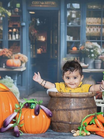 This little one is having a great time at the farmer's market, surrounded by fresh vegetables.