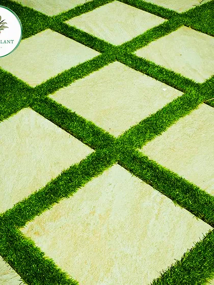 Quality is in the details. This is a close-up of a lawn I installed at a Chattarpur farmhouse, featuring a clean design with stone pavers set in lush artificial grass. This technique is great for creating stylish and durable garden pathways.
