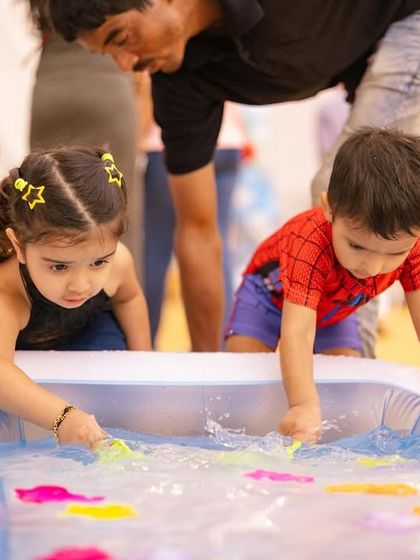 Little ones completely absorbed in the 'fishing shack' game. This activity is great for younger kids, allowing them to have their own water fun in a shallow, safe pool.