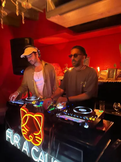 Going back-to-back with Kahani at a 'Fur A Cause' event. The red-lit room and neon sign created a cool, intimate setting for our set.