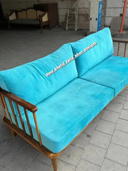 Front view of the turquoise spindle-back sofa.