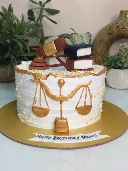 Another law-themed cake, this one with a more classic design. It features a fondant gavel, law books, and the scales of justice, all finished in elegant gold.