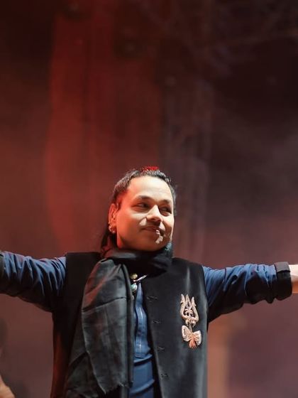 Kailash Kher in his signature pose, holding a damru. This shot captures his unique blend of folk energy and spiritual devotion on stage at the Ganga Kinare Music Festival.