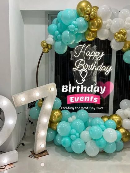 A duplicate of image 17, this setup for a 27th birthday uses a fresh color palette of turquoise, white, and gold, paired with large marquee numbers.