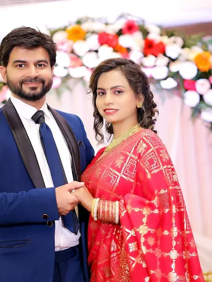 The happy couple posing in front of a beautiful floral arch at their engagement ceremony. A classic shot to remember the day.
