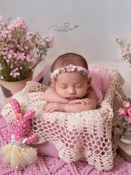 Pretty in pink. This classic setup with a pink blanket, floral headband, and a potted plant is sweet, simple, and absolutely timeless.