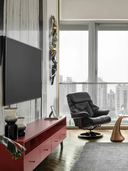 A view of the master bedroom, showing the comfortable lounge chair by the window. It's the perfect spot to enjoy the city views, blending the outdoors with the serene interior.