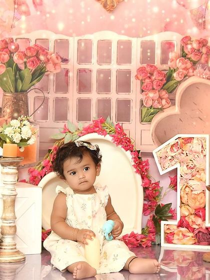 A dreamy pink floral setup for a first birthday princess. The soft colors and abundant flowers create a romantic and beautiful scene.