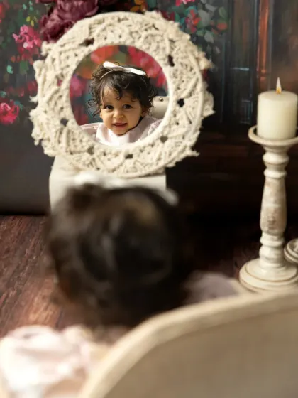 A smile in the mirror. Using props like this macrame mirror adds a creative and interactive element to the photoshoot.