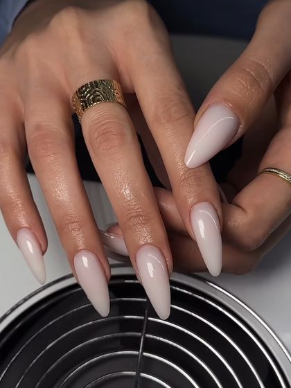 A stunning set of long, milky-nude stiletto nails. The color is soft and understated, while the shape adds drama.