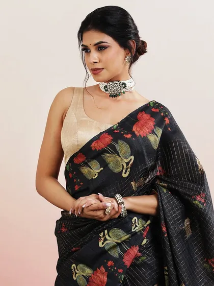 A black saree with a beautiful print of swans and lotus flowers, a classic and elegant choice.