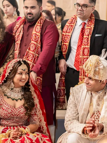 A lovely candid shot of the bride and groom during their wedding rituals. Her classic red lehenga and glowing makeup make for a picture-perfect moment.